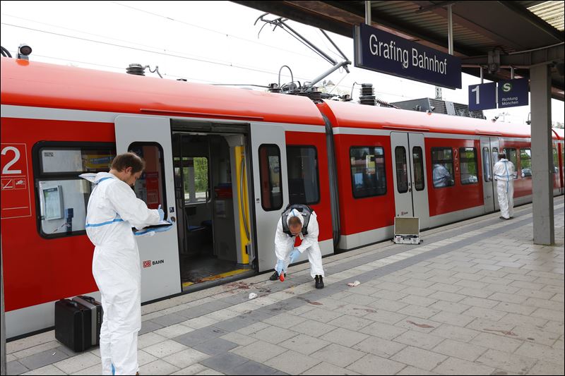 Police investigate the scene of a stabbing at a station in Grafing near Munich Germany today. Police said one person has died in a hospital after the stabbing. Police said the suspected assailant is a 27-year-old German national