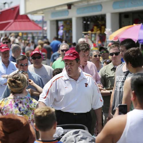 Gov. Chris Christie center greets people as he walks along an already crowded boardwalk to kick off the Memorial Day holiday weekend at the Jersey Shore Friday