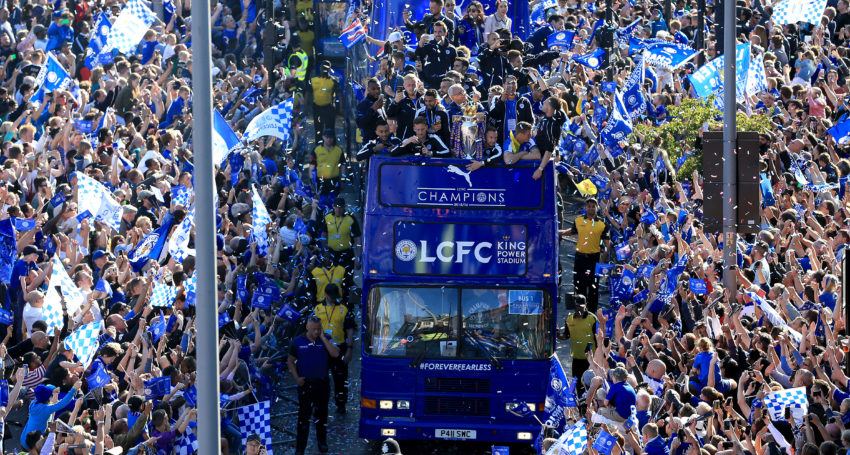 Leicester City players and staff celebrate with the trophy during the open top bus parade through Leicester City Centre