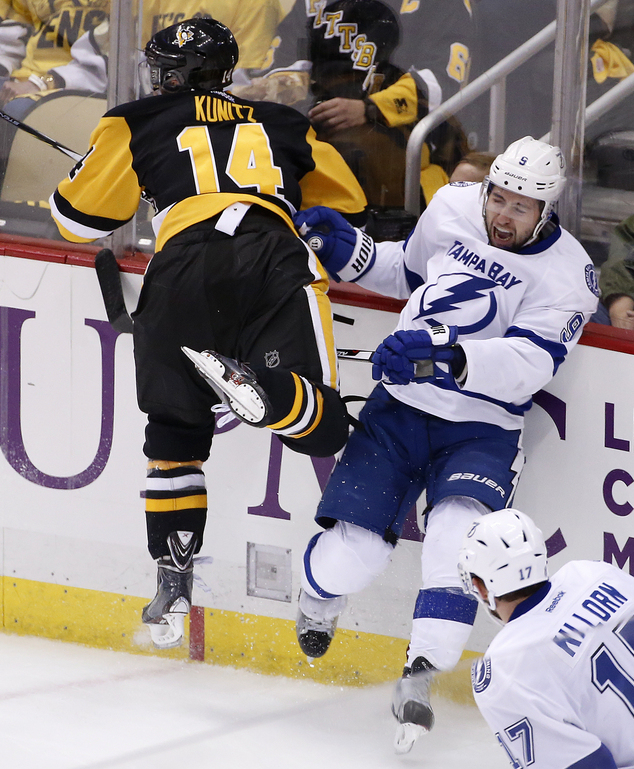 Tampa Bay Lightning's Tyler Johnson is checked into the boards by Pittsburgh Penguins Chris Kunitz during the first period of Game 1 of the NHL hockey S