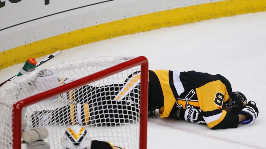 Pittsburgh Penguins&#x27 Brian Dumoulin lies on the ice after being hit into the boards by Tampa Bay Lightning's Ondrej Palat during the third period of Game 1 of the NHL hockey Stanley Cup Eastern Conference finals Friday