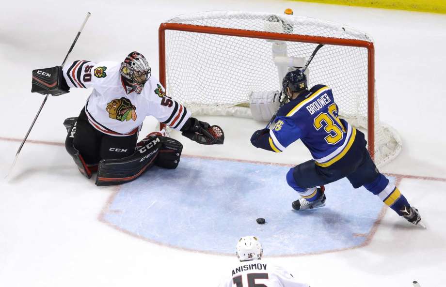 St. Louis Blues Troy Brouwer right reaches for a loose puck before scoring past Chicago Blackhawks goalie Corey Crawford left during the third period in Game 7 of an NHL hockey first-round Stanley Cup playoff series Monday