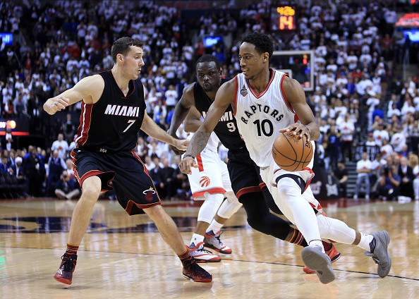 DeMar De Rozan #10 of the Toronto Raptors dribbles the ball as Goran Dragic #7 and Luol Deng #9 of the Miami Heat defend in the second half of Game One of the Eastern Conference Semifinals during the 2016 NBA Playoffs at the Air Canada Centre