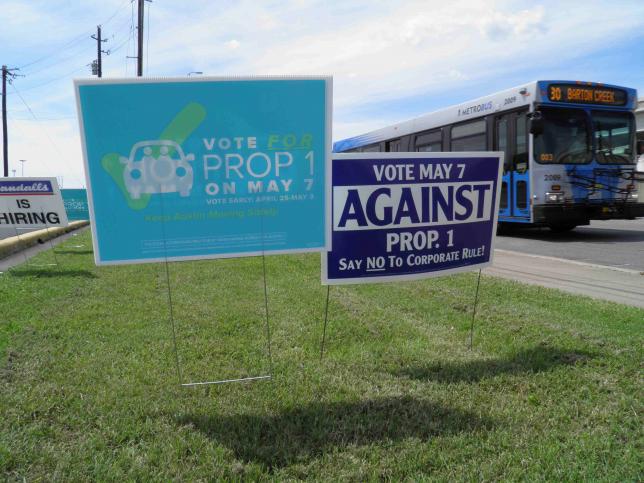 Campaign signs concerning a municipal vote over fingerprint requirements for ride-hailing companies such as Uber and Lyft are seen along a roadway in Austin Texas