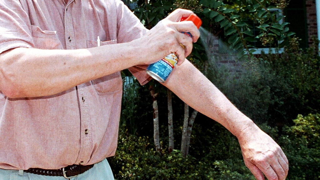 Man sprays mosquito repellent