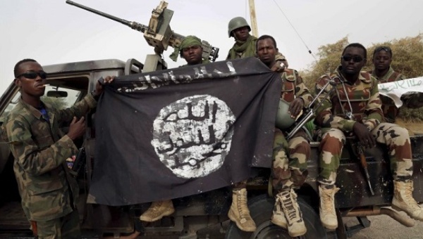 Nigerian soldiers hold up a Boko Haram flag that they had seized in the recently retaken town of Damasak Nigeria