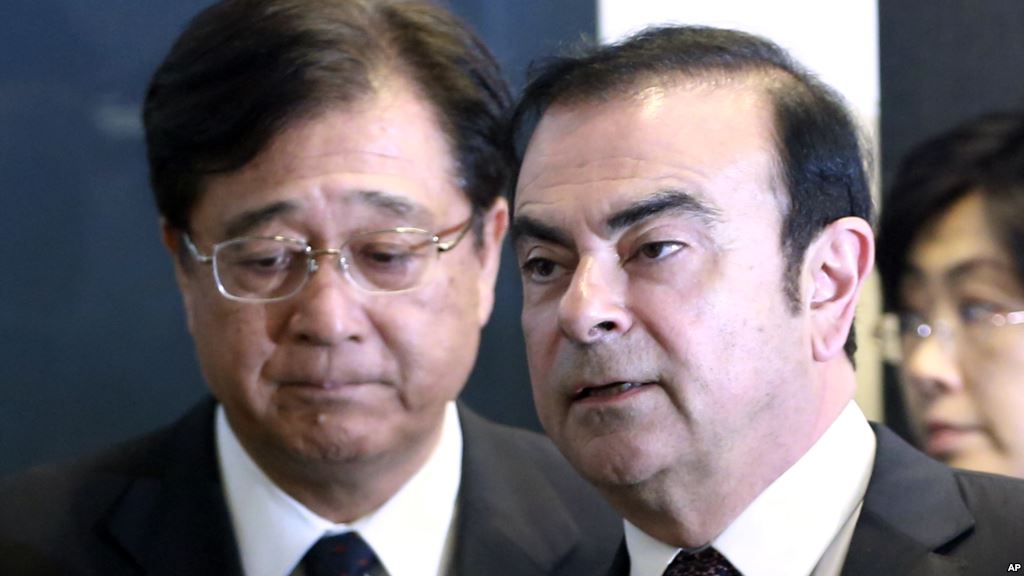 Nissan Motor Co. President and CEO Carlos Ghosn right and Mitsubishi Motors Corp. Chairman and CEO Osamu Masuko walk in the venue of their joint press conference in Yokohama near Tokyo Thursday