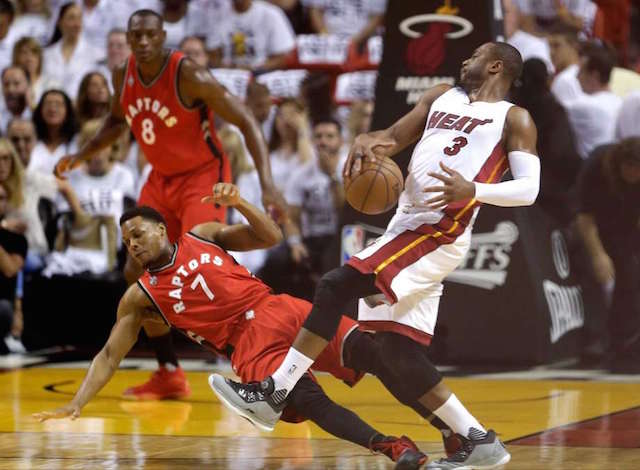 Miami Heat's Dwyane Wade collides with Toronto Raptors Kyle Lowry as he makes a move to the basket during the first half of Game 6 of the NBA basketball Eastern Conference semifinals Friday