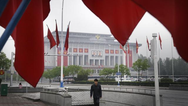 North Korean man walks out of an underpass while seen framed by the Workers Party flags