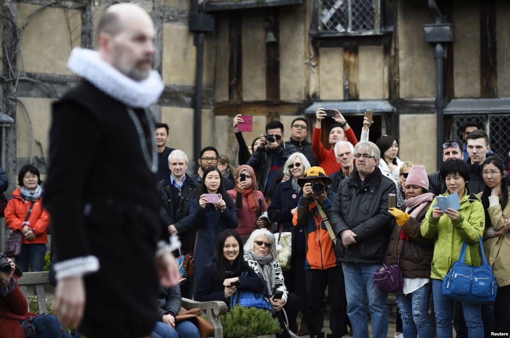 Tourists watch actors perform at the house where William Shakespeare was born during celebrations to mark the 400th anniversary of the playwright's death in Stratford-Upon-Avon England