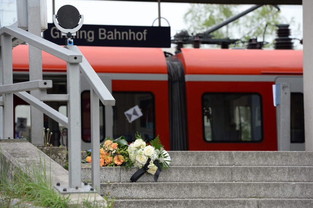 Flowers have been placed on the stairs leading to a platform at the railway station in Grafing near Munich Germany on Tuesday. One man died and three people were injured in a knife attack that may have been politically motivated and occurred at the loca