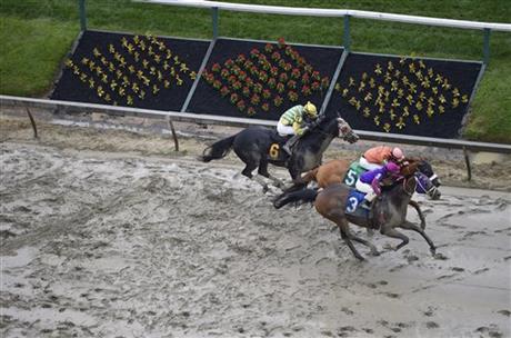 Homeboykris, ridden by Horacio Karamanos wins the first race of the day on a muddy track ahead of the 141st Preakness Stakes horse race at Pimlico Race Course Saturday