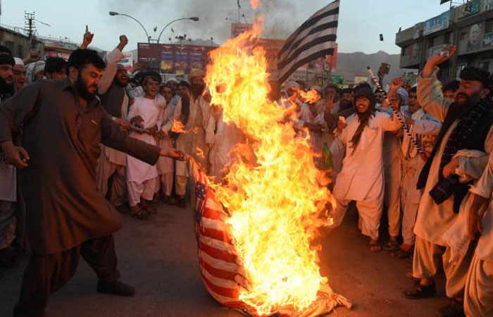 Pakistani supporters of hard-line pro Taliban party Jamiat Ulema-i-Islam-Nazaryati torch a US flag during a protest in Quetta against a US drone strike in Pakistan's southwestern province Balochistan in which killed Afghan Taliban leader Mullah Ak