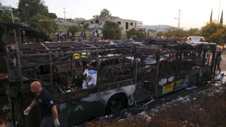 Israeli police forensic experts work at the scene after an explosion tore through a bus in Jerusalem on Monday and set a second bus on fire in what an Israeli official said was a bombing Israel