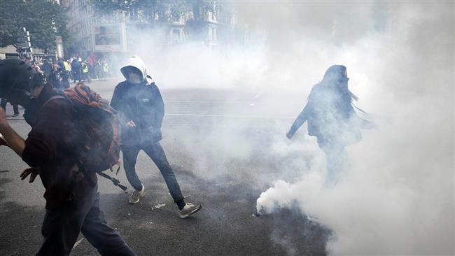 People stand amid smoke during a demonstration against the government's labor law reform. AFP