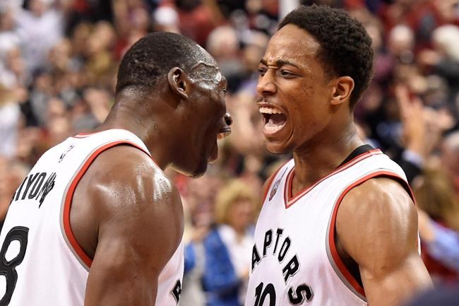 Toronto Raptors guard De Mar DeRozan celebrates his team's victory over the Indiana Pacers with teammate Bismack Biyombo after NBA basketball playoff action in Toronto on Tuesday