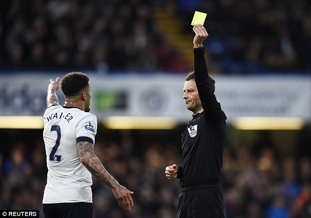 Premier League official Mark Clattenburg shows Tottenham right back Kyle Walker a yellow card