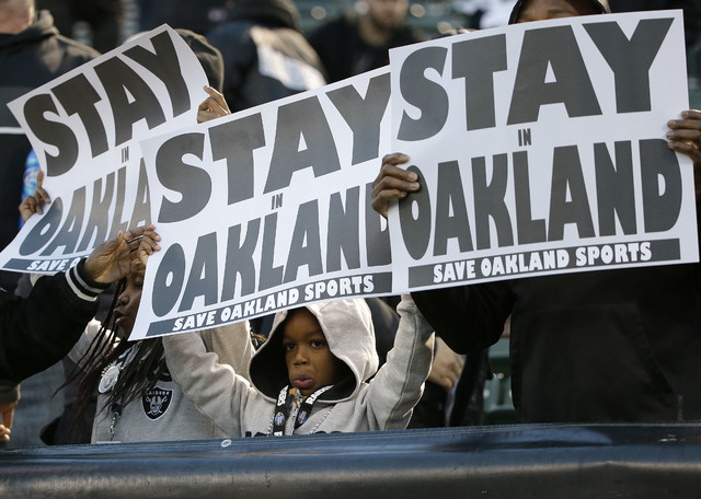 ASSOCIATED PRESS           Fans held up a sign for the Oakland Raiders to stay in Oakland before a Dec. 24 game between the Oakland Raiders and the San Diego Chargers in Oakland Calif. Raiders owner Mark Davis said he wants to move