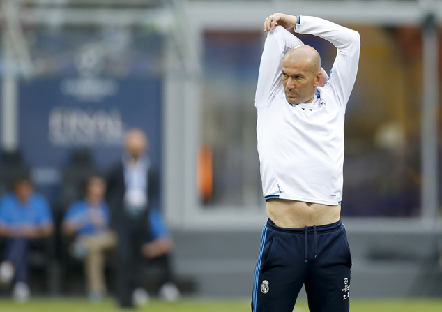 Real Madrid's coach Zinedine Zidane stretches during a training session at the San Siro stadium in Milan Italy Friday