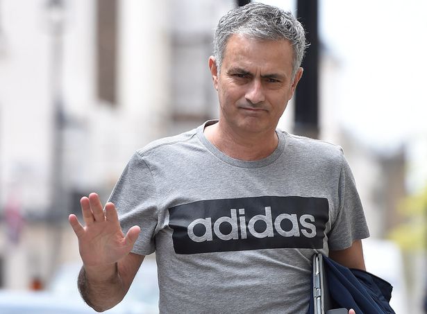 Jose Mourinho gestures as he walks towards his house in London