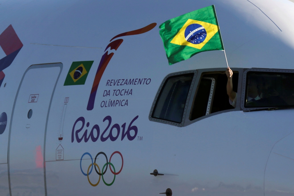 Reuters  Ueslei MarcelinoA pilot waves a Brazilian national flag during the arrival of the Olympic flame in Brasilia Brazil