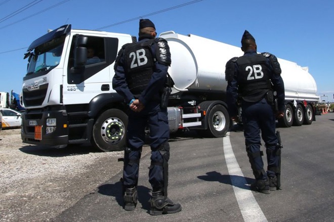 Riot police secure tanker trucks arriving to refuel at a refinery in Southern France