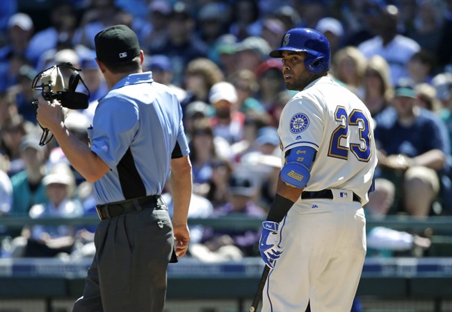 Seattle Mariners Nelson Cruz right talks with home plate umpire D.J. Reyburn after Cruz was called out on strikes to end the first inning of a baseball game against the Kansas City Royals Sunday