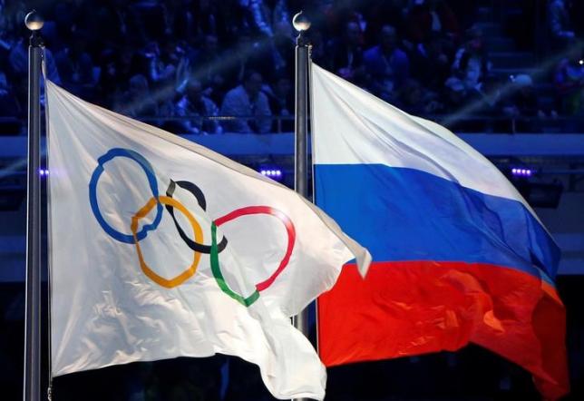 The Russian national flag and the Olympic flag are seen during the closing ceremony for the 2014 Sochi Winter Olympics Russia