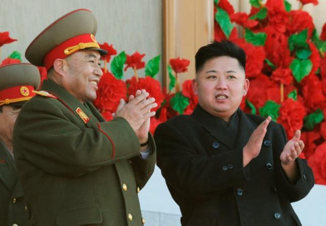 North Korean leader Kim Jong Un exchanges smiles with Ri Yong-ho during a military parade to mark the birth anniversary of the North's late leader Kim Jong Il in Pyongyang in this