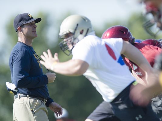 Michigan football coach Jim Harbaugh looks on during the Coach Jim Harbaugh's Elite Summer Football Camp Friday