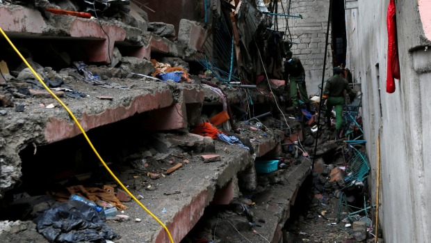 Rescue workers search for residents feared trapped in the rubble of a six-storey building that collapsed after days