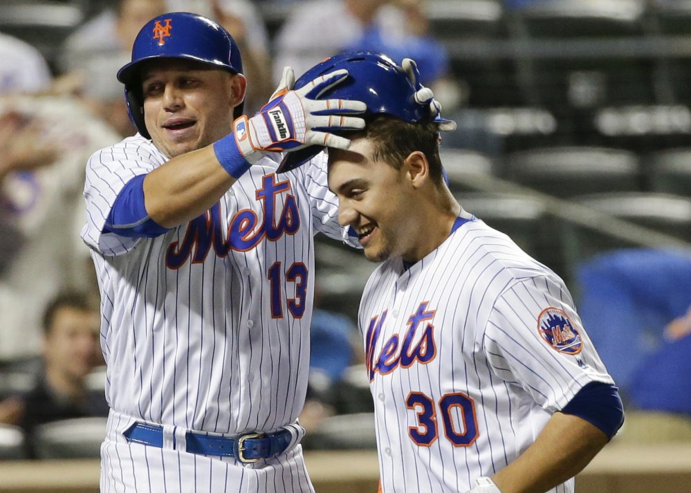 Asdrubal Cabrera of the New York Mets takes the helmet off Michael Conforto after they scored on Conforto's two-run home run in a 3-2 win over the Brewers at New York on Friday