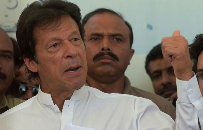 Pakistani cricketer-turned-opposition leader Imran Khan speaks to media as he arrives at the parliament building to attend a special session in Islamabad on Monday. — AFP