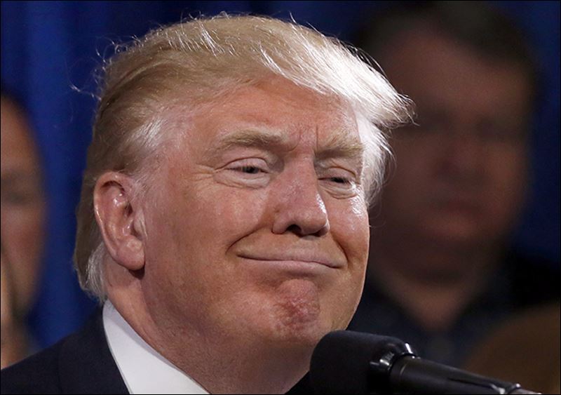 Republican presidential candidate Donald Trump smiles as he stands with 22 delegates from North Dakota to the Republican National Convention who are the core of delegates that elevated Trump over the 1237 needed for the GOP's presidential nomination