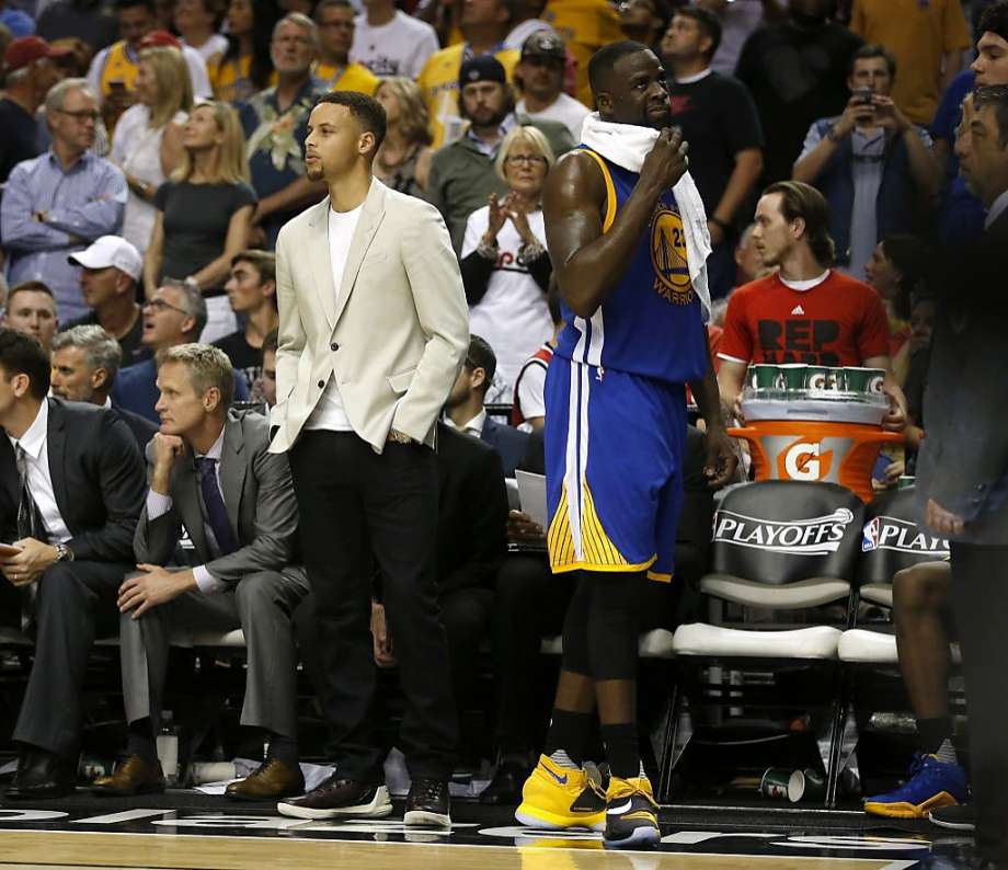 The Golden State Warriors Draymond Green and injured Stephen Curry watch the final seconds of a 120-108 loss to the Portland Trail Blazers late in Game 3 of the Western Conference semifinals at the Moda Center in Portland Ore. on Saturday May 7