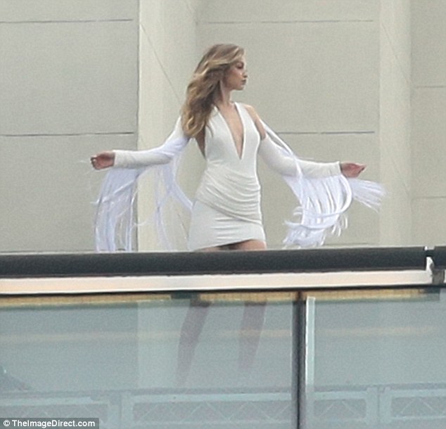 Strike a pose Model Gigi Hadid wore a plunging white mini dress as she filmed a new Maybelline ad campaign in New York City on Friday