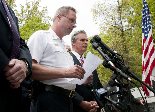 Auburn Police Chief Andrew Sluckis reads a statement about Auburn police Officer Ronald Tarentino who was was fatally shot during a traffic stop in Auburn Mass. Sunday. Worcester County District Attorney Joseph D. Early Jr. right joins Sluckis at the