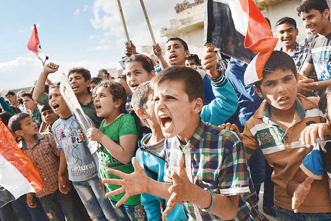 Syrian’s react to the arrival of a Russian military convoy. Pic  AFP