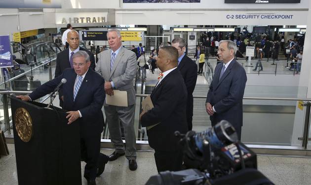 As Sen. Cory Booker back left D-N.J. Rep. Albio Sires D-N.J. back second from left Rep. Donald Payne Jr. third from right D-N.J. and others listen Sen. Bob Menendez D-N.J. front left announces the Transportation Security Administration is