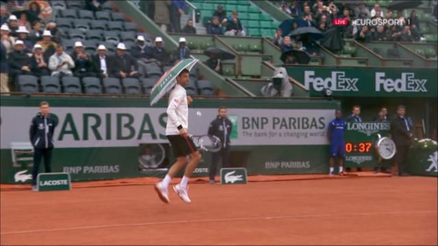 Djokovic borrows fan's umbrella for some fun in the rain