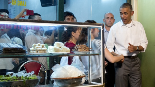 The US President greets women at the door as he walks from the Bun Cha Huong Lien restaurant