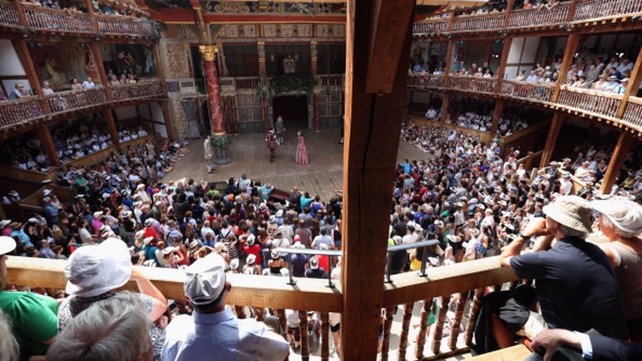 Theatregoers enjoy the sunshine during a performance at the Globe theatre in London