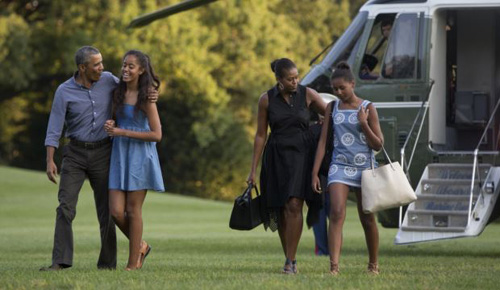 From left President Barack Obama with daughter Malia and first lady Michelle Obama with daughter Sasha walk form Marine One across the South Lawn of the White House in Washington on Aug. 23 2015. /AP