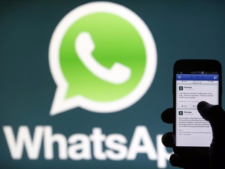 A Whatsapp App logo is seen behind a Samsung Galaxy S4 phone that is logged on to Facebook in the central Bosnian town of Zenica