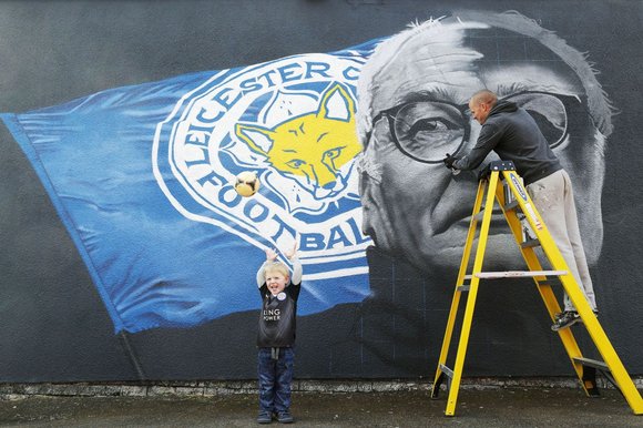 Three-year-old Rivers Hubbard in front of a mural celebrating Leicester manager Claudio Ranieri