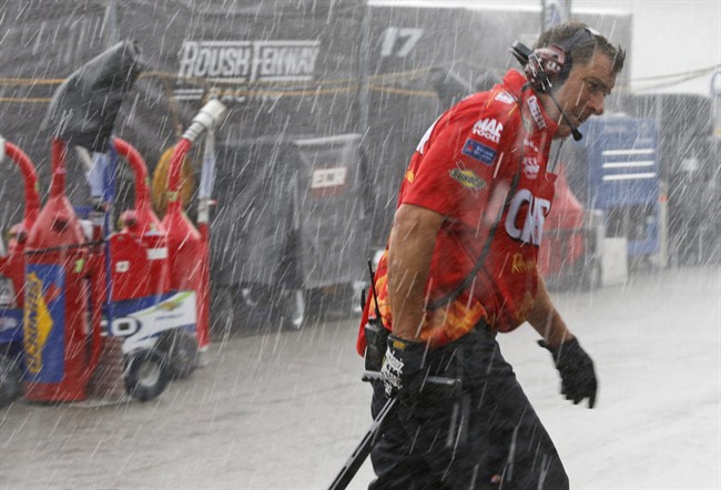 A crew member for Greg Biffle heads to the garage as a rainstorm stops practice for Sunday's NASCAR Sprint Cup auto race at Richmond International Raceway in Richmond Va. Friday