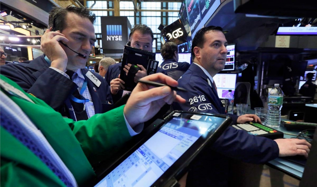 Traders gather at the post of James Sciulli right on the floor of the New York Stock Exchange Thursday