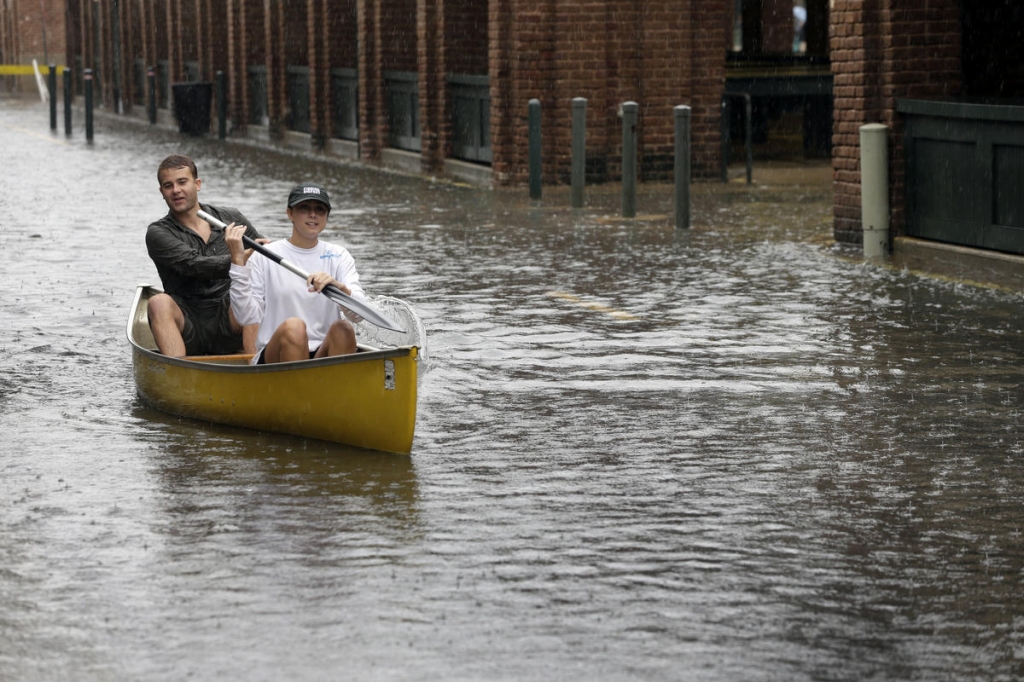 Dillon Christ front and Kyle Barnell paddle their canoe down a flooded street in Charleston S.C. The U.S. government released its forecast for how many hurricanes and tropical storms are expected to form over Atlantic