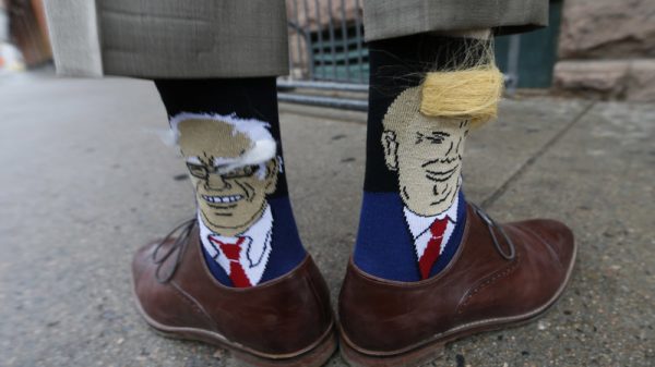 Colorado Gov. John Hickenlooper shows off his socks — one with Democratic presidential candidate Bernie Sanders and the other with Republican candidate Donald Trump. David Zalubowski  AP