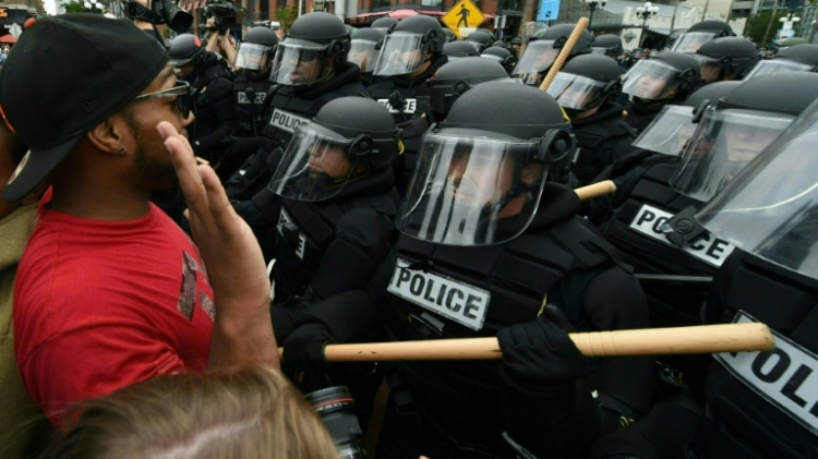 A protester argues with police during a rally against Republican presidential candidate Donald Trump outside his event in San Diego California